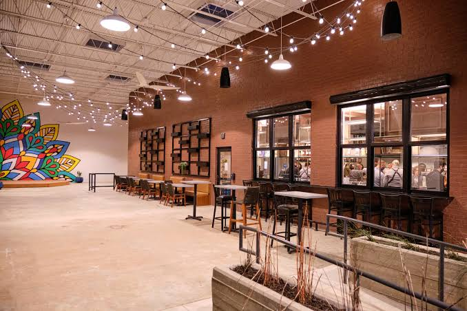 The Woodall restaurant event space with brick walls, string lights, and a colorful mural